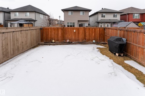 The property features a fenced yard with a combination of wooden and reddish-brown privacy fencing - 22742 95A Ave, Edmonton, AB - Outdoor