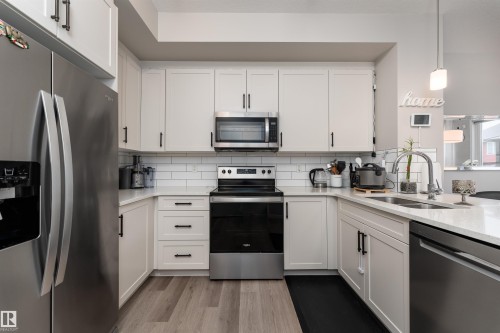 The kitchen features white cabinetry, stainless steel appliances, and a white subway tile backsplash - 22742 95A Ave, Edmonton, AB - Indoor Photo Showing Kitchen With Double Sink