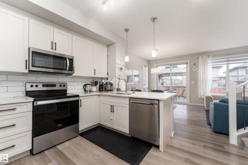 Well-appointed kitchen featuring white cabinetry, stainless steel appliances, and a subway tile backsplash - 22742 95A Ave, Edmonton, AB - Indoor Photo Showing Kitchen With Upgraded Kitchen