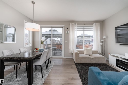 The dining area features a large table with seating and an overhead light fixture - 22742 95A Ave, Edmonton, AB - Indoor