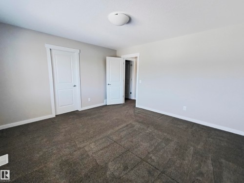 This room features light grey walls and dark grey carpet, with white trim and white doors - 8008 18 Avenue Sw, Edmonton, AB - Indoor Photo Showing Other Room