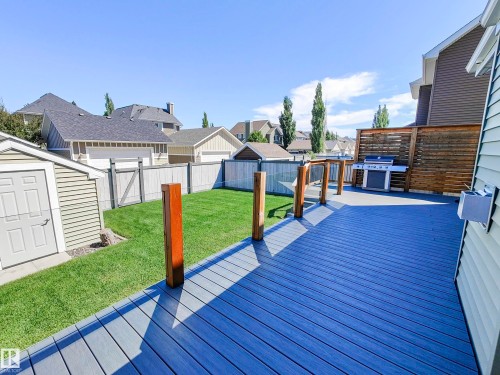 The property features an outdoor deck with a gray surface and wooden railings - 8008 18 Avenue Sw, Edmonton, AB - Outdoor With Deck Patio Veranda With Exterior