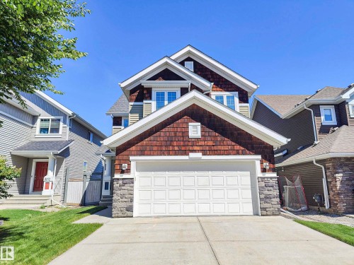The property features a two-car garage, a concrete driveway, and a well-maintained lawn - 8008 18 Avenue Sw, Edmonton, AB - Outdoor