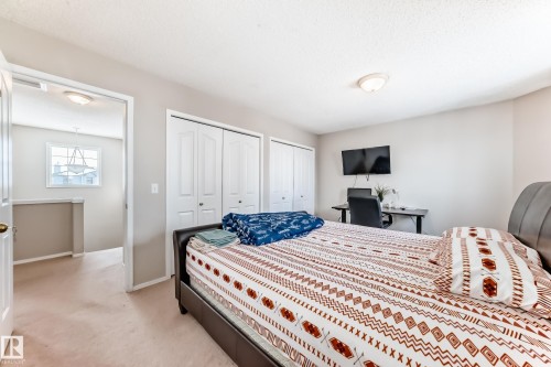 This room features light-colored carpeting, a ceiling-mounted light fixture, and white bi-fold closet doors - 19024 50 Avenue, Edmonton, AB - Indoor Photo Showing Bedroom