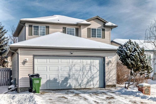 The property features a two-story exterior with light-colored siding, a two-car garage, and multiple windows with dark shutters - 19024 50 Avenue, Edmonton, AB - Outdoor