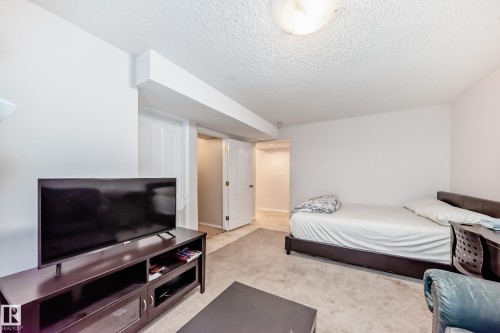 This interior space features light-colored walls and carpeting, with a ceiling light fixture providing illumination - 19024 50 Avenue, Edmonton, AB - Indoor Photo Showing Bedroom