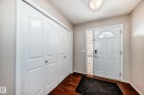The entryway features a white front door with an arched window, a white interior door, and dark wood flooring - 19024 50 Avenue, Edmonton, AB  - Indoor Photo Showing Other Room 