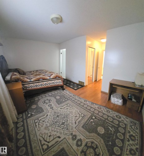 The property features light wood flooring, a ceiling-mounted light fixture, and white painted walls - 16912 110 Street, Edmonton, AB - Indoor Photo Showing Bedroom