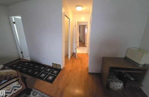 Hallway featuring hardwood floors, white walls, and recessed lighting - 16912 110 Street, Edmonton, AB - Indoor