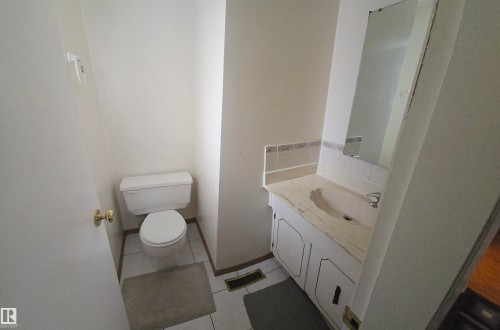 Bathroom featuring a vanity with a sink, a mirror, and a toilet - 16912 110 Street, Edmonton, AB - Indoor Photo Showing Bathroom