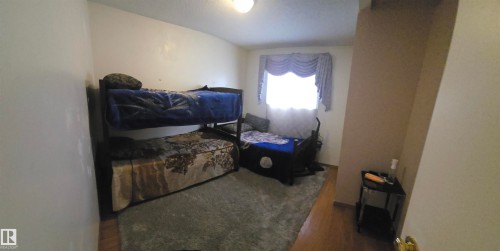 The room features wood flooring and a light-colored accent wall - 16912 110 Street, Edmonton, AB - Indoor Photo Showing Other Room