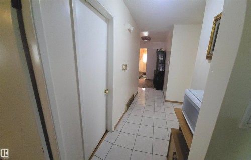 The property features a hallway with white tile flooring and light-colored walls - 16912 110 Street, Edmonton, AB - Indoor Photo Showing Other Room