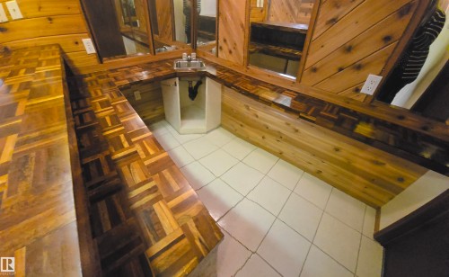 This space features distinctive wooden countertops with a patterned design, a stainless steel sink with a faucet, and light-colored tiled flooring - 16912 110 Street, Edmonton, AB - Indoor Photo Showing Other Room