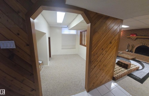 This property features a room with light-colored carpet, white walls, and an overhead fluorescent light fixture - 16912 110 Street, Edmonton, AB - Indoor Photo Showing Other Room