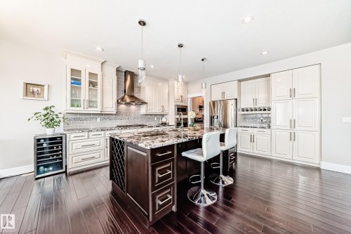 The kitchen features dark wood flooring, light cabinetry, and granite countertops - 4134 Charles Link, Edmonton, AB - Indoor Photo Showing Kitchen With Upgraded Kitchen