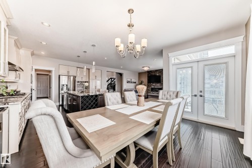 The open-concept main floor features dark wood flooring and recessed lighting - 4134 Charles Link, Edmonton, AB - Indoor Photo Showing Dining Room