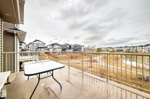 The property includes a balcony with a railing, offering views of a pond and a paved walking path - 4134 Charles Link, Edmonton, AB - Outdoor