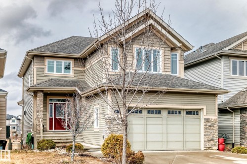 The property features a two-story design with a prominent front-facing gable, horizontal siding, and stone accents - 4134 Charles Link, Edmonton, AB - Outdoor With Facade