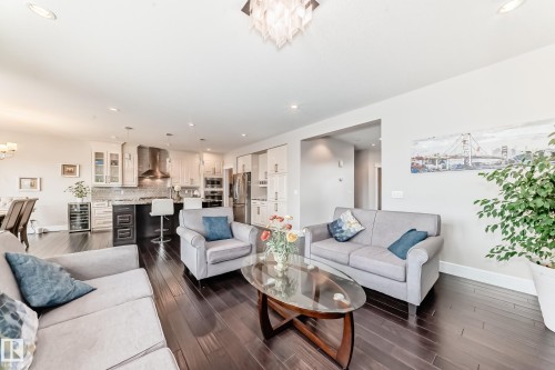 The property features dark wood flooring throughout the open concept living space - 4134 Charles Link, Edmonton, AB - Indoor Photo Showing Living Room