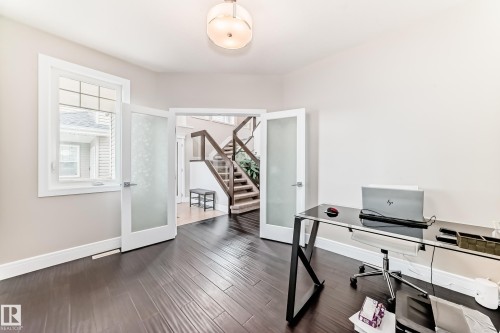 This room features dark hardwood flooring, light-colored walls, and a window with white trim - 4134 Charles Link, Edmonton, AB - Indoor Photo Showing Office