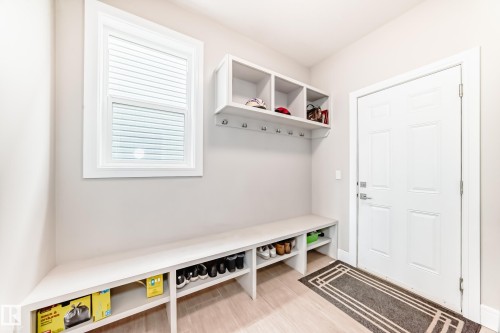 Entryway featuring a white door, a window with blinds, and built-in shelving with hooks - 4134 Charles Link, Edmonton, AB - Indoor Photo Showing Other Room