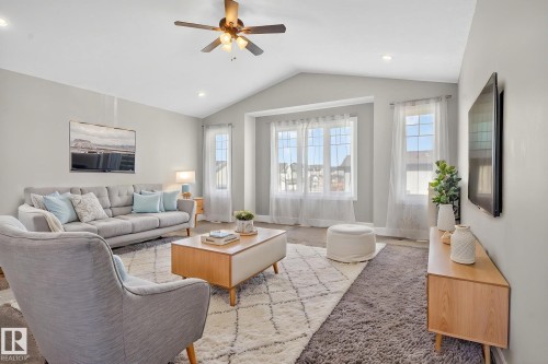 The living area features vaulted ceilings, recessed lighting, and a ceiling fan - 4134 Charles Link, Edmonton, AB - Indoor Photo Showing Living Room