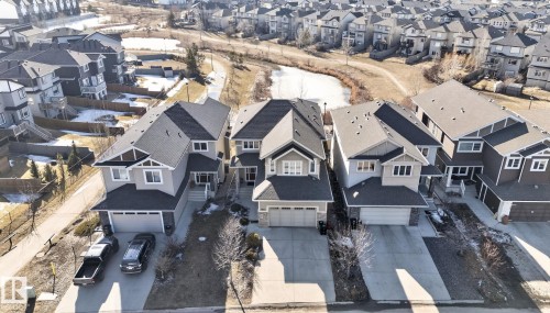 The property features a two-story design with a gray exterior, a dark roof, and an attached garage - 4134 Charles Link, Edmonton, AB - Outdoor With Facade