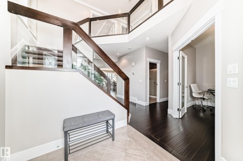 Grand entryway with a contemporary staircase featuring dark wood and glass railings - 4134 Charles Link, Edmonton, AB - Indoor Photo Showing Other Room