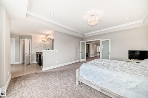 Bedroom featuring carpeting, a coffered ceiling with a chandelier, and double doors with frosted glass panels - 4134 Charles Link, Edmonton, AB - Indoor Photo Showing Bedroom
