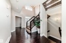 Entryway featuring dark hardwood flooring, a staircase with dark wood railings and carpeted treads, and a multi-pane front door with side panels - 4134 Charles Link, Edmonton, AB  - Indoor Photo Showing Other Room 