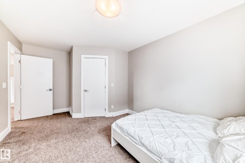 This room features carpeted flooring, a light-colored ceiling, and white baseboards - 4134 Charles Link, Edmonton, AB - Indoor Photo Showing Bedroom