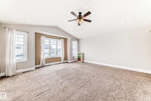 Spacious room featuring vaulted ceilings, a ceiling fan with integrated lighting, recessed lighting, and expansive windows - 4134 Charles Link, Edmonton, AB - Indoor Photo Showing Other Room