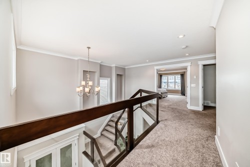 The property features a spacious landing with carpeted flooring, recessed lighting, and a modern chandelier - 4134 Charles Link, Edmonton, AB - Indoor Photo Showing Other Room