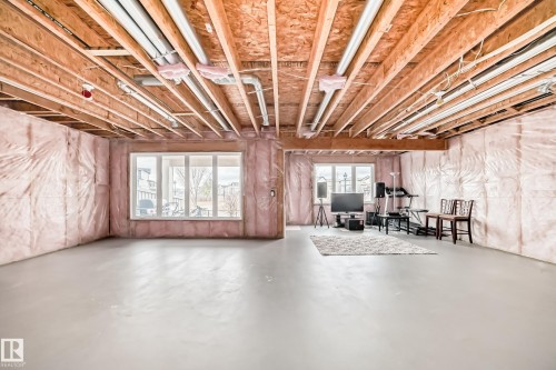 Expansive unfinished basement featuring visible insulation, concrete flooring, and windows providing natural light - 4134 Charles Link, Edmonton, AB - Indoor Photo Showing Basement