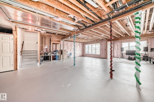 An unfinished basement with exposed wooden joists and insulation, offering potential for customization - 4134 Charles Link, Edmonton, AB - Indoor Photo Showing Basement