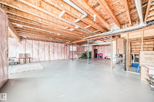 The property features a spacious unfinished basement with exposed wooden joists and insulation, offering potential for customization - 4134 Charles Link, Edmonton, AB - Indoor Photo Showing Basement