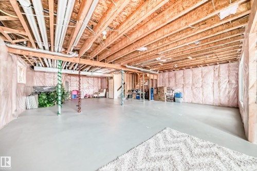 The property features a spacious unfinished basement with exposed wooden joists and insulated walls, offering significant potential for customization - 4134 Charles Link, Edmonton, AB - Indoor Photo Showing Basement