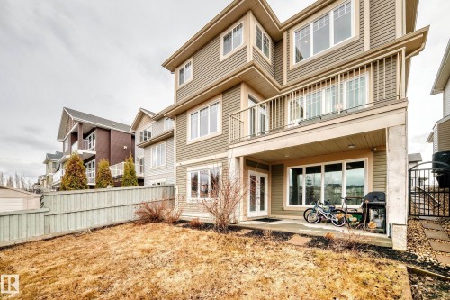 The property features a multi-level exterior with horizontal siding, a balcony with a railing, and a ground-level patio area - 4134 Charles Link, Edmonton, AB - Outdoor With Deck Patio Veranda