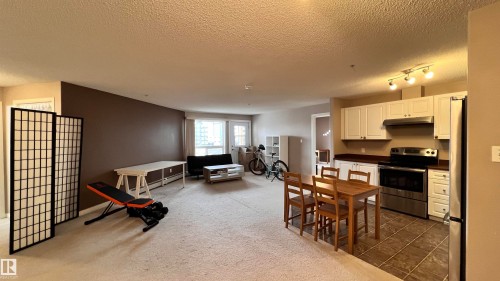 The open concept living area features carpeted flooring and an expansive window, providing natural light - 1318 330 Clareview Station Drive Nw, Edmonton, AB - Indoor