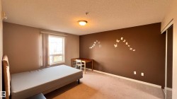 The room features a window with vertical blinds, providing natural light - 