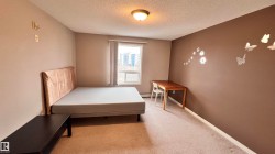This bedroom features a window providing natural light, carpeted flooring, and a ceiling light fixture - 