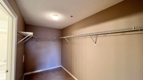 Walk-in closet featuring wire shelving, a clothing rod, and carpeted flooring - 1318 330 Clareview Station Drive Nw, Edmonton, AB - Indoor With Storage