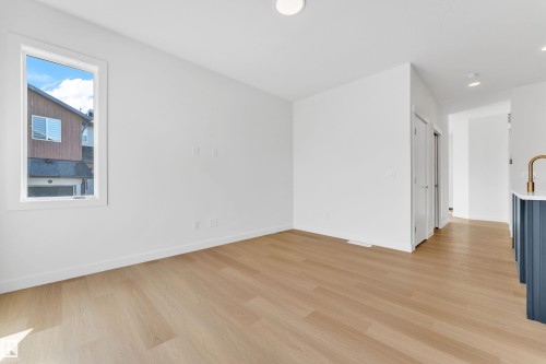 Bright room featuring light-toned flooring, white walls, and a window providing natural light - 57 710 Mattson Drive, Edmonton, AB - Indoor Photo Showing Other Room