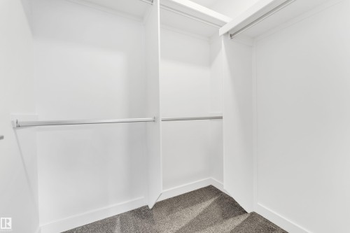 The property features a closet with built-in shelving, hanging rods, and a carpeted floor - 57 710 Mattson Drive, Edmonton, AB - Indoor Photo Showing Other Room