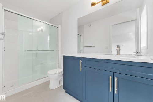 Bathroom with a spacious vanity featuring a blue cabinet and a white countertop - 57 710 Mattson Drive, Edmonton, AB - Indoor Photo Showing Bathroom