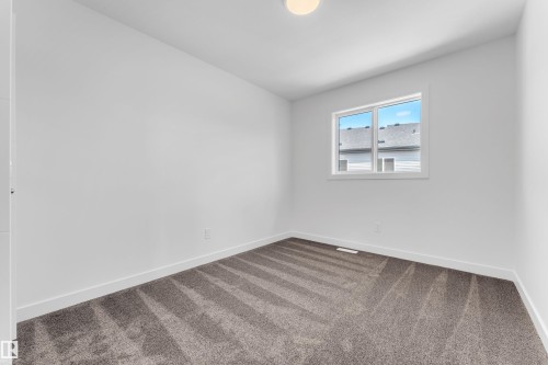 The room features neutral white walls, a window providing natural light, and grey carpet flooring - 57 710 Mattson Drive, Edmonton, AB - Indoor Photo Showing Other Room