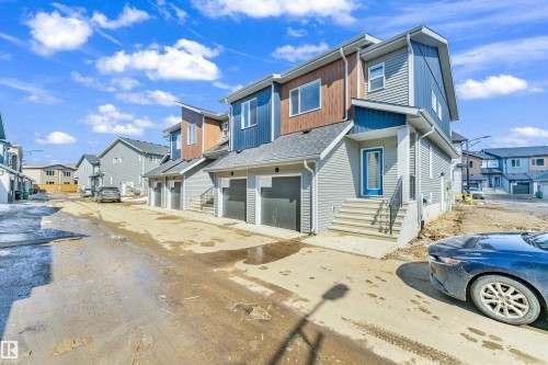 The property features a contemporary exterior with multi-toned siding, including blue and grey panels, and a wood-look accent on the upper level - 57 710 Mattson Drive, Edmonton, AB - Outdoor