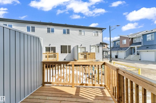 The property features a newly constructed wooden deck with railings, providing an outdoor living space - 57 710 Mattson Drive, Edmonton, AB - Outdoor With Exterior