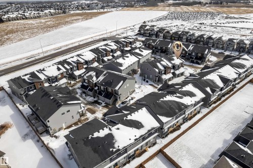 Aerial view of a residential neighbourhood featuring a collection of properties with dark roofs and light-colored siding - 57 710 Mattson Drive, Edmonton, AB -  With View