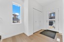 The entryway features light-colored wood flooring, a white door with a window, and a white closet with double doors - 57 710 Mattson Drive, Edmonton, AB  - Indoor Photo Showing Other Room 